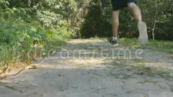 年轻的肌肉运动员在森林小径上奔跑积极的强壮的男人在户外训练身材健美的运动员视频的预览图