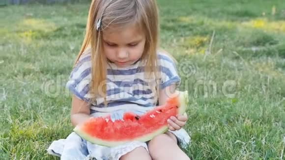 夏天可爱的小女孩在草地上吃西瓜视频的预览图