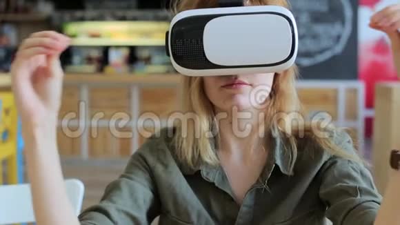 在咖啡馆里戴着虚拟现实眼镜的年轻女子视频的预览图