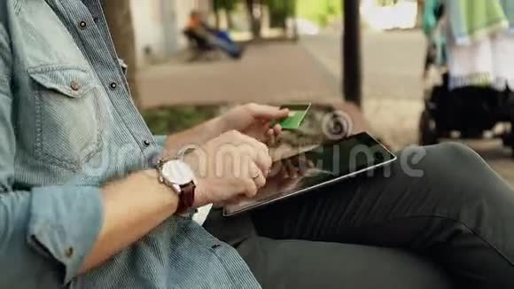 使用平板电脑上网购物时携带信用卡的帅哥视频的预览图
