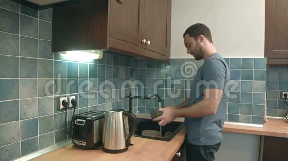 在家厨房洗碗的年轻人视频的预览图