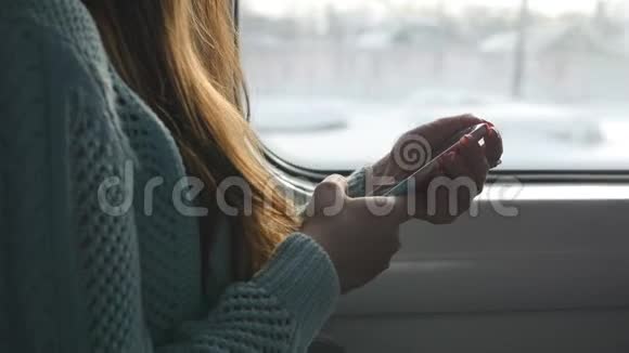 女性在火车上使用手机在铁路上旅行时年轻女子打智能手机的手臂关门视频的预览图