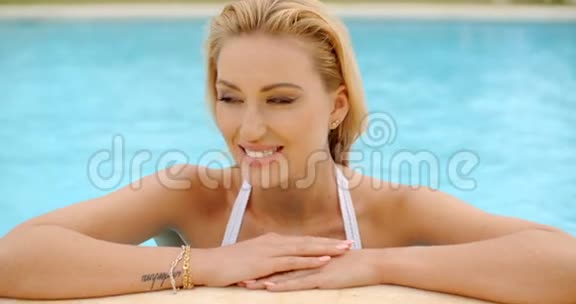 美丽的金发女人在泳池边视频的预览图