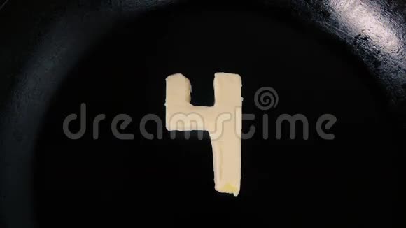 在热锅上融化4号形状的黄油关闭顶部视图视频的预览图