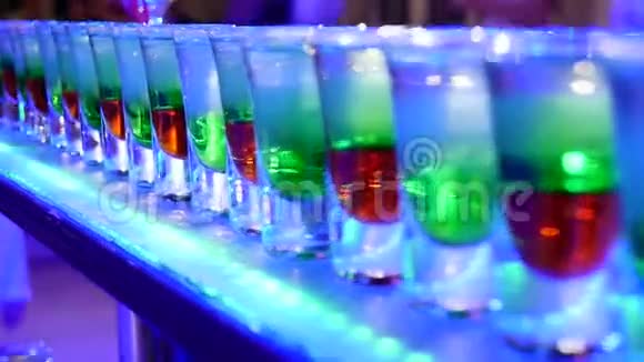 一组五颜六色的小瓶子酒精鸡尾酒白色桌子上的利口酒视频的预览图