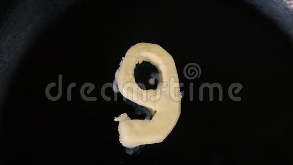 在热锅上融化9号形状的黄油关闭顶部视图视频的预览图