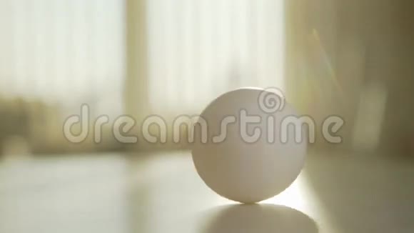 鸡蛋在桌子上旋转用手旋转一个鸡蛋它首先快速转动视频的预览图