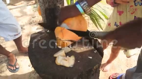 近距离观看一位当地男子为幼儿切新鲜椰子饮料视频的预览图
