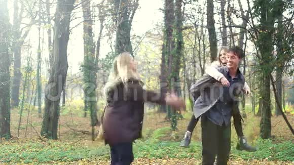 在公园里向女儿和丈夫扔树叶的女人视频的预览图