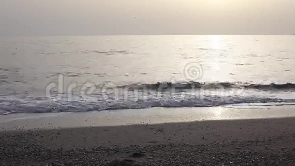 在夕阳的海面上奔跑的女子剪影视频的预览图