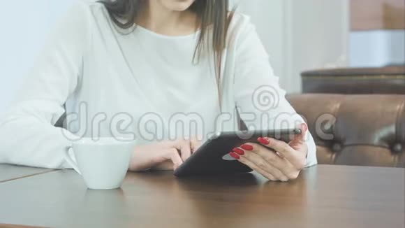 女性手拿平板电脑和咖啡杯视频的预览图