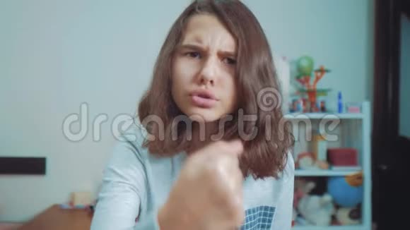 少女愤怒的手势拳头威胁慢动作视频女孩用拳头威胁少女要求视频的预览图