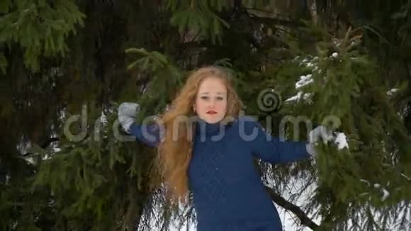 一个美丽的时尚模特微笑和看镜头红色的长发冬天飘雪视频的预览图