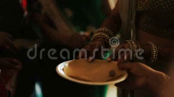 印度女人在盘子上摆动坚果视频的预览图