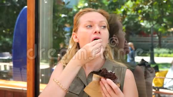 一个胖女人在咖啡馆里吃一个小蛋糕然后啜饮咖啡4k慢动作视频的预览图