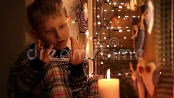 可爱的小男孩坐在窗台上数着圣诞节前剩下的日子视频的预览图