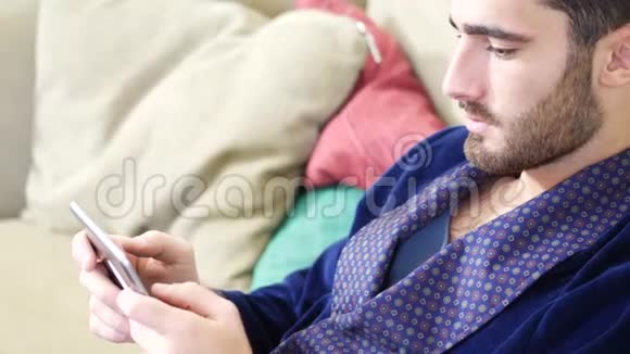 年轻人用平板电脑在沙发上看书视频的预览图