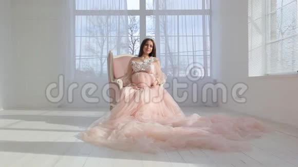 穿着粉红色长裙的年轻怀孕少女视频的预览图