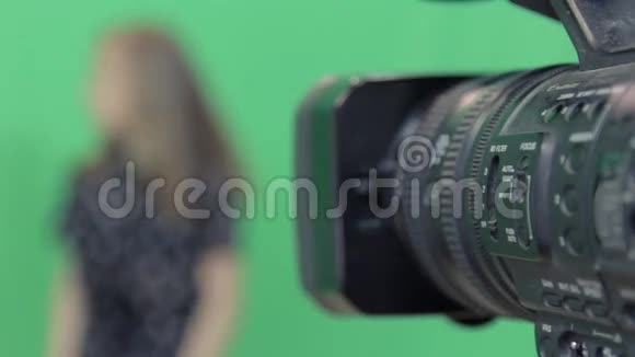 一个女孩正在绿色背景下录制节目视频的预览图