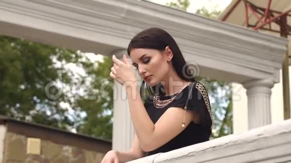 穿着优雅衣服的女士靠在栏杆上视频的预览图