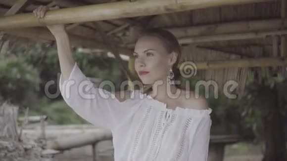 漂亮自然的女人穿着波霍风格的时尚穿着白色衬衫帽子和耳环在一个美丽的夏天视频的预览图
