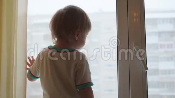 一个孩子站在窗台上望着窗外视频的预览图