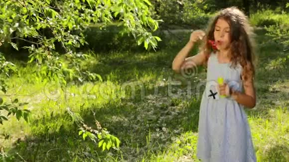 快乐的小女孩在户外玩肥皂泡笑着笑视频的预览图