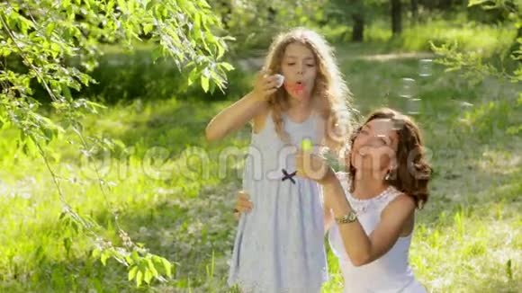 美丽的年轻母亲和她的女儿一起做肥皂泡视频的预览图