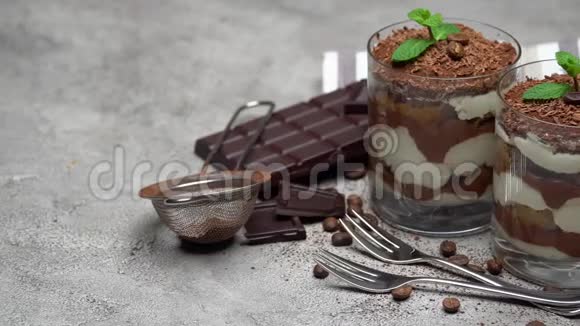 两份经典的提拉米苏甜点在玻璃和巧克力棒的具体背景视频的预览图