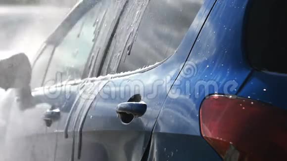 一辆蓝色的汽车在闪亮的一天用喷水冲洗视频的预览图