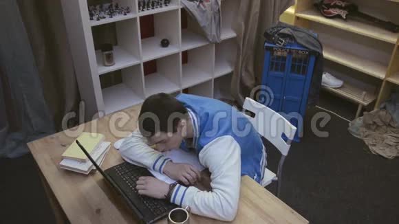 男孩在前笔记本上睡觉后醒来瞥一眼床单微笑伸展学生视频的预览图