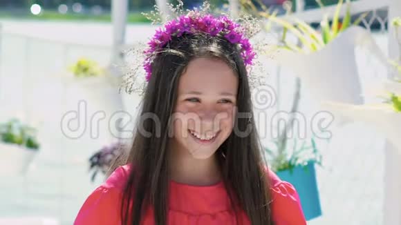 快乐的年轻女孩在手里嗅着花在海湾酒吧微笑慢慢地视频的预览图