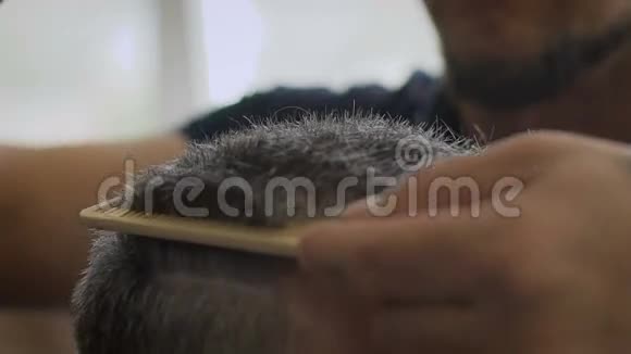 理发店里的白发男子时尚的Barber条纹客户使用梳子和剪刀缓慢移动视频的预览图
