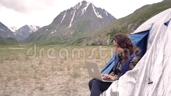 女游客带着笔记本电脑指纹作品坐在扶手椅上的群山中视频的预览图