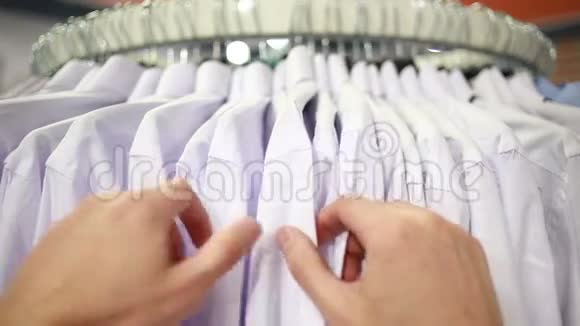 在时装店里寻找T恤衫的男性顾客视频的预览图