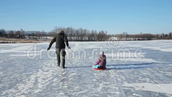父亲和女儿在冰冻的湖面上滑视频的预览图