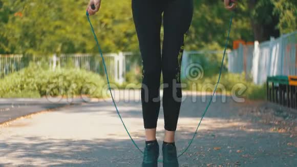 年轻运动员穿着舒适的运动服装在公园的运动场上跳绳视频的预览图