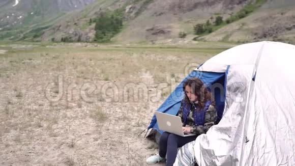 女游客带着笔记本电脑指纹作品坐在扶手椅上的群山中视频的预览图