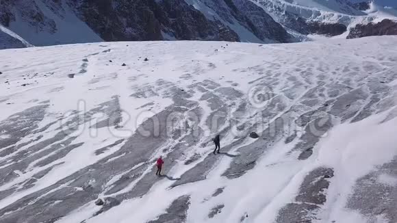 空中一个男人和一个女人爬上阿拉斯加的一座高山专业步行者从事徒步旅行视频的预览图