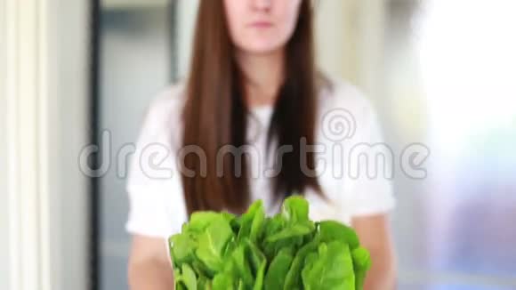 女人手里拿着一束菠菜的景象视频的预览图