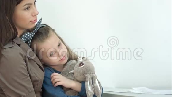 年轻的妈妈和她的小女儿带着小兔子去看医生视频的预览图