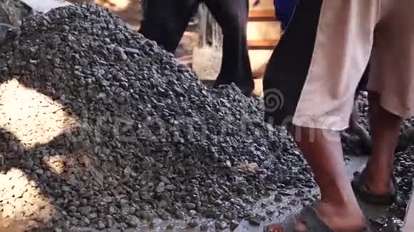 建筑工人赤脚用铁锹人工搅拌混凝土视频的预览图