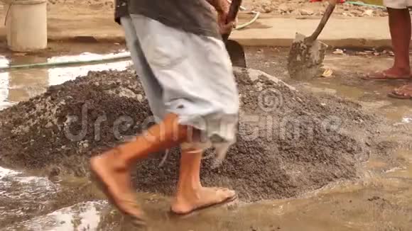 建筑工人赤脚用铁锹人工搅拌混凝土视频的预览图