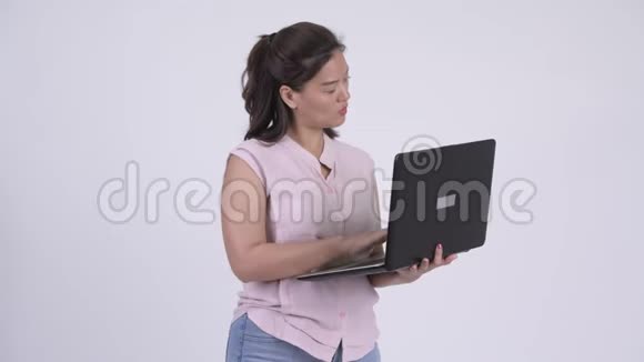 年轻快乐的亚洲女商人用笔记本电脑思考问题视频的预览图