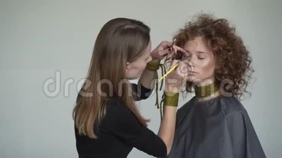 专业化妆师的特写镜头是将红色唇彩运用到模特身上视频的预览图