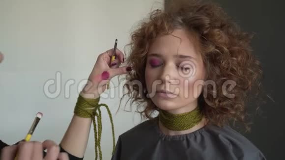 专业化妆师的特写镜头是将红色唇彩运用到模特身上视频的预览图