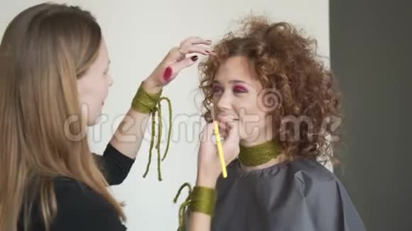 专业化妆师将色调粉涂于长卷发蓝眼睑金发模特视频的预览图