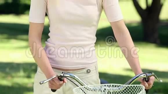 在公园骑自行车的漂亮女孩视频的预览图