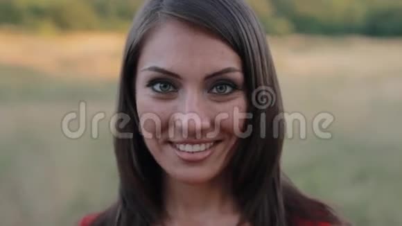 在镜头前微笑的迷人年轻女子的特写镜头视频的预览图