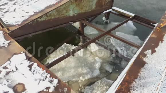 旧码头下的冰在春天漂浮在河上视频的预览图